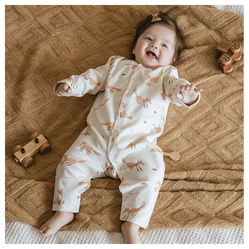 Adorable baby wearing a Gourbear vintage fox pattern baby romper, lying happily on a blanket comfortably 